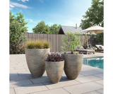 Ardesia Textured Stone Luxury Planter in grey, planted by a pool terrace