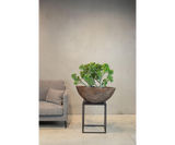 Bertarelli Curved Wave Luxury Table Planter in bronze, on a stand in a living room