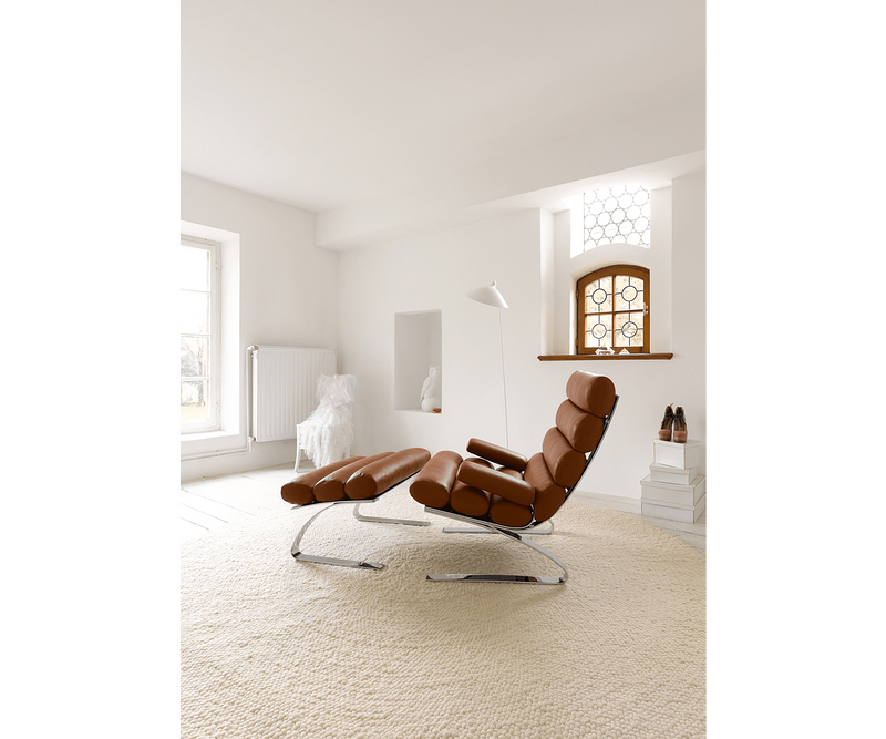 High-end living room furniture featuring the Sinus Armchair, showcasing sleek design and superior craftsmanship.