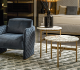 Anello diamond quilted armchair beside marble side tables in a living room