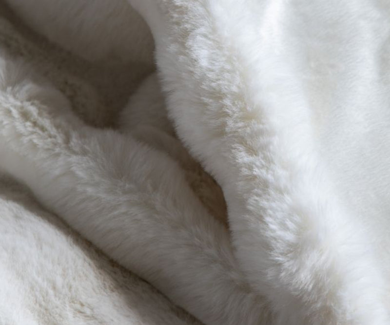 Elevate your modern living room with the Neutral Cream Faux Fur Throw. This luxurious throw, crafted from soft faux fur in a timeless cream colour, complements any space.