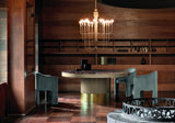 Curvo round marble dining table with lazy susan and brass plinth in a walnut panelled dining room