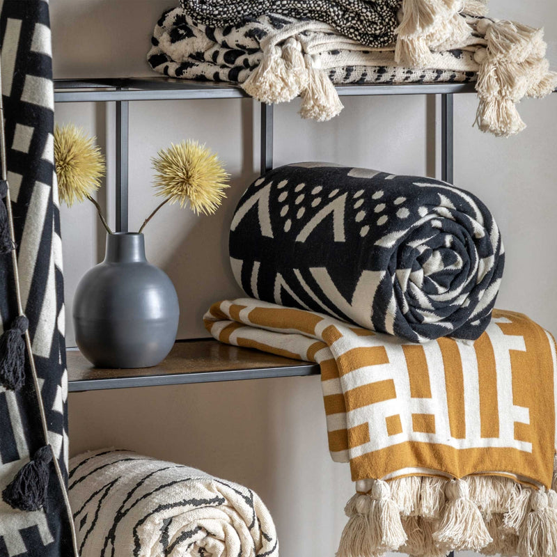 Cosy Comfort Meets Modern Style: Ochre & Cream Knit Throw with Tassels. Sink into pure comfort with this ochre and cream knit throw featuring charming cream tassels. Perfect for adding a touch of warmth and contemporary style to your bedroom.