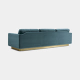 Touched D luxury sofa in teal velvet, three-quarter rear view showing the satin brass base