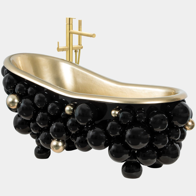 High-end bathroom bathtub featuring a gold-painted cast iron tub with sculptural black lacquered spheres, perfect for luxury master bathroom designs.