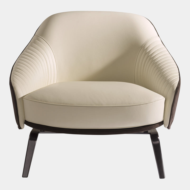 Visionnaire's Whitney Armchair: Ergonomic Comfort Meets Artistic Design. This modern armchair boasts a curved frame for exceptional support, luxurious canneté quilted fabric upholstery with contrasting leather accents, and a customisable stainless steel base. Perfect for any discerning luxury interior design enthusiast.